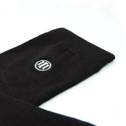 Detail foto van de zwarte bamboe sokken afgewerkt met het geborduurd logo